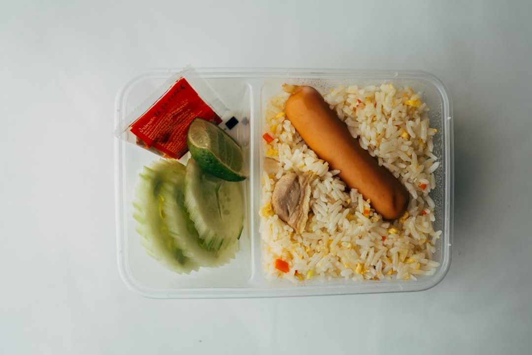 meal prep for athletes - a plastic container filled with rice and a hot dog