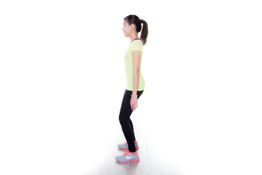 Personne en position de flexion des jambes sans charge, observée dans une salle