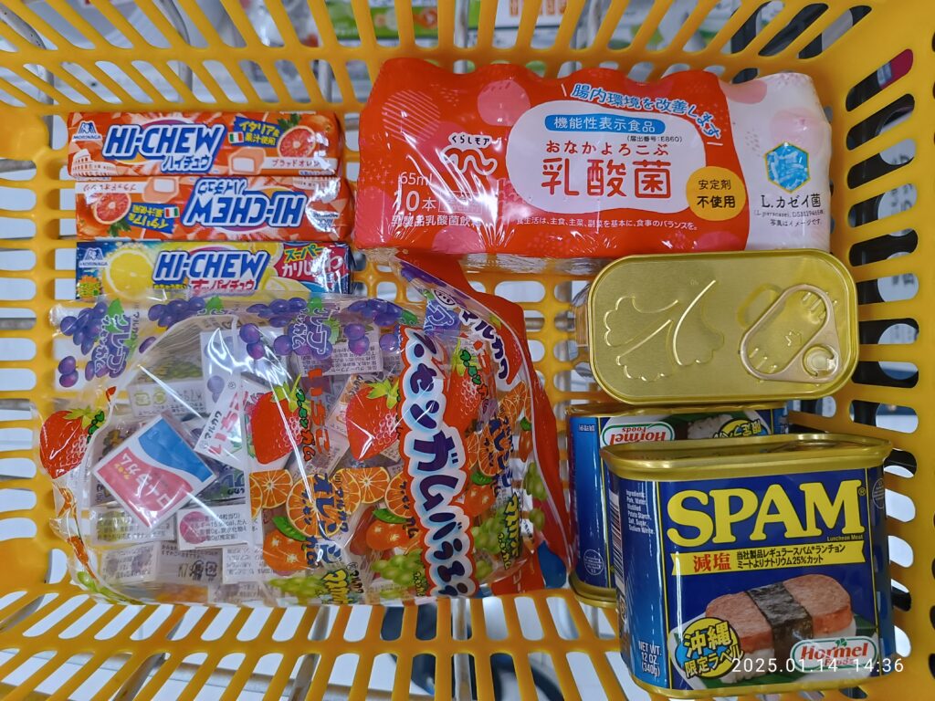 Panier de courses en plastique tenu à la main devant un rayon de supermarché