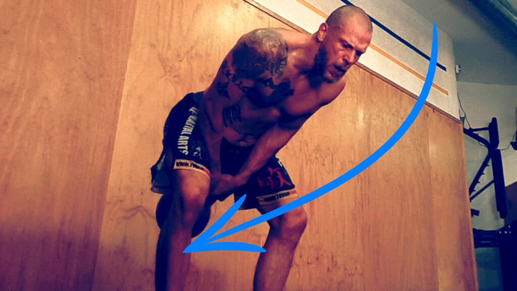 Pratiquant en position basse d'un swing, bassin recul&eacute; et dos droit, kettlebell entre les cuisses