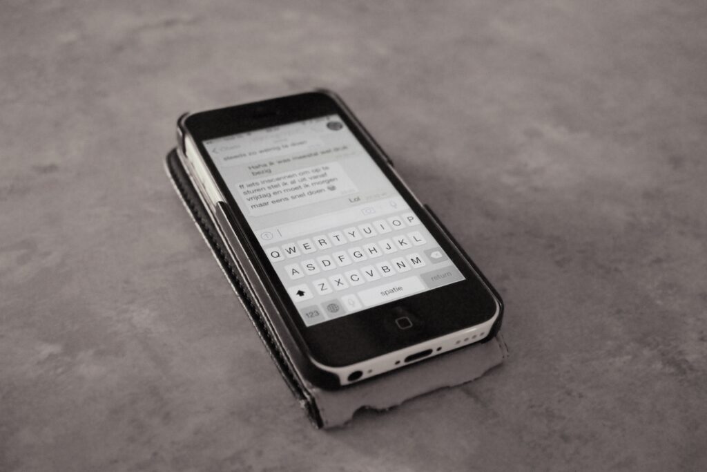Écran de téléphone affichant une conversation courte tenu au-dessus d'un sac de sport