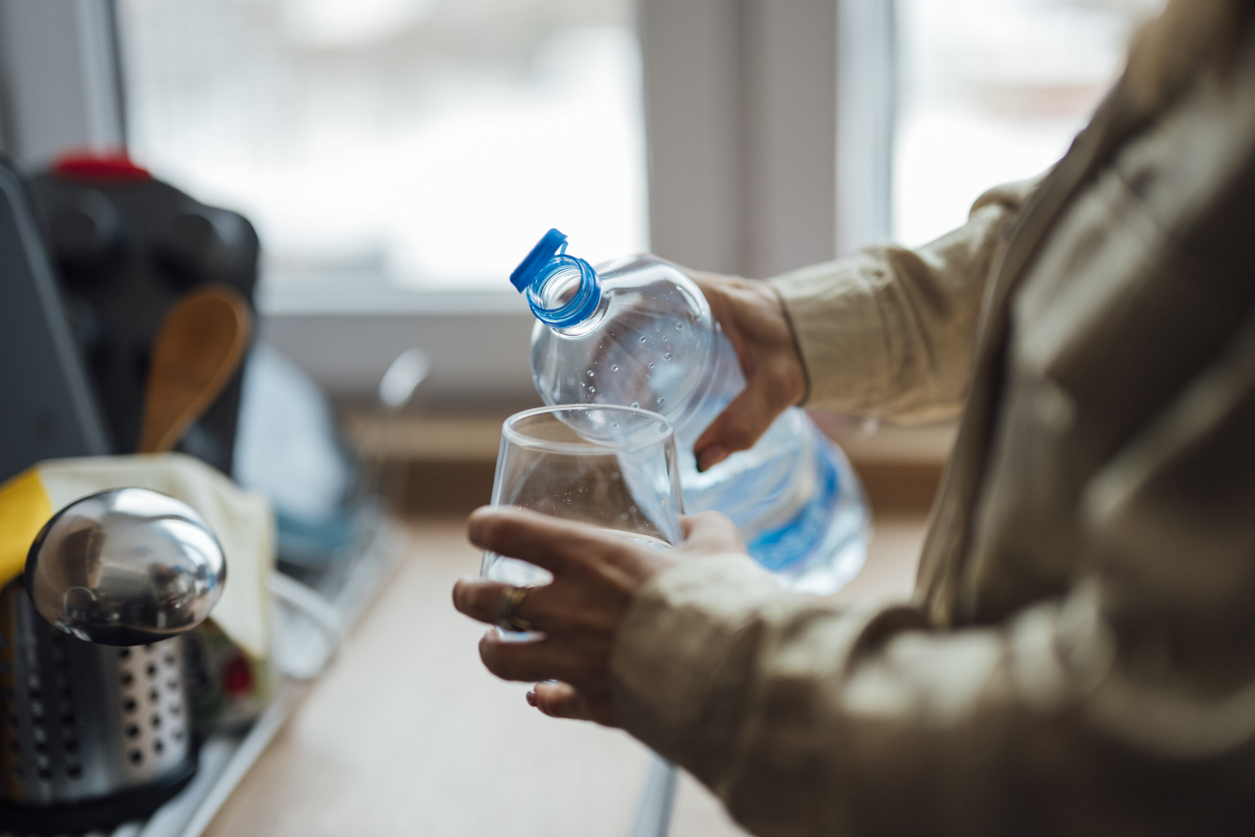 Bouteille d'eau remplie d'un liquide légèrement teinté posée sur un plan de travail avec du citron