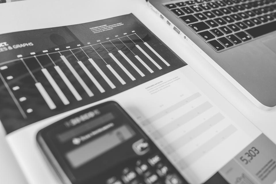 Calculatrice posée sur une table à côté de plusieurs tickets et d'un carnet ouvert